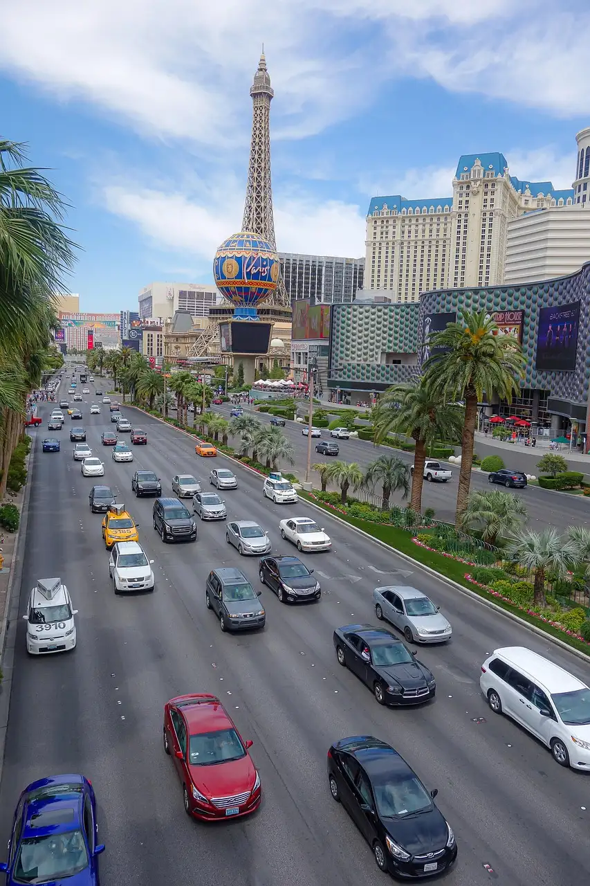 Cars driving along Las Vegas Boulevard on the Strip, with the Paris tower in the distance