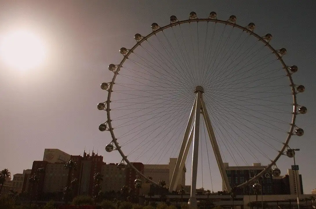 The High Roller observation wheel in full, its cabins ringing the rim, against a hazy sunny sky