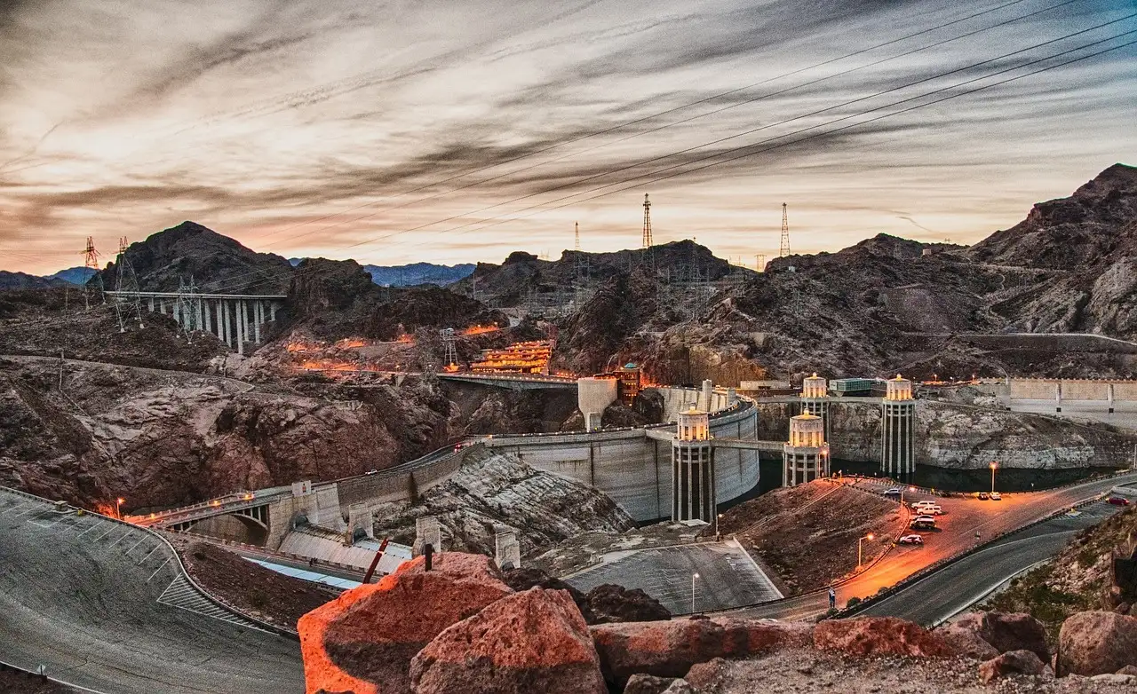 Hoover Dam with its intake towers and the bypass bridge at sunset
