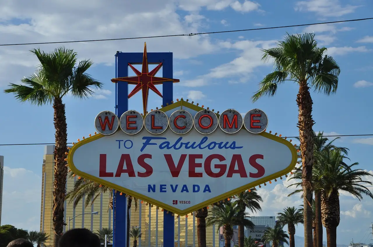 The Welcome to Fabulous Las Vegas sign between palm trees under a blue sky