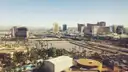 Las Vegas Strip resort towers on a clear day, seen from high up across palms and parking lots