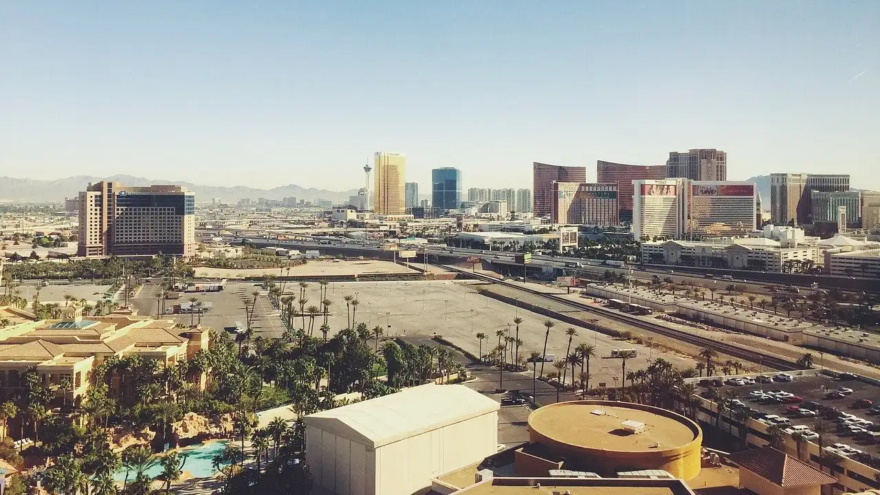 Las Vegas Strip resort towers on a clear day, seen from high up across palms and parking lots