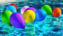 Colorful balloons floating on bright blue pool water