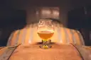 Glass of pale beer standing on a wooden barrel