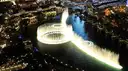 The Bellagio fountains from above at night, a ring of jets on the dark lake