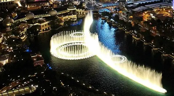 The Bellagio fountains from above at night, a ring of jets on the dark lake