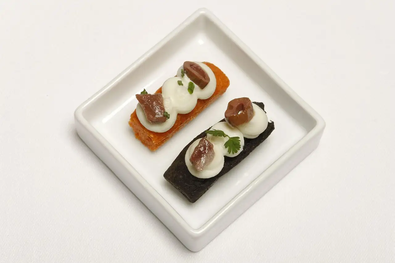 Two canapés on a small square white plate