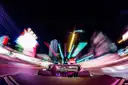 Open convertible driving down the Las Vegas Strip at night, neon lights blurred into streaks