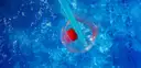 Drink with a strawberry and blue straw against pool water