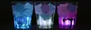 Three glasses with ice glowing blue, white and purple