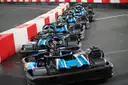Row of empty go-karts along red and white track barriers
