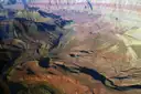Air view down into a deep canyon with a river between layered slopes
