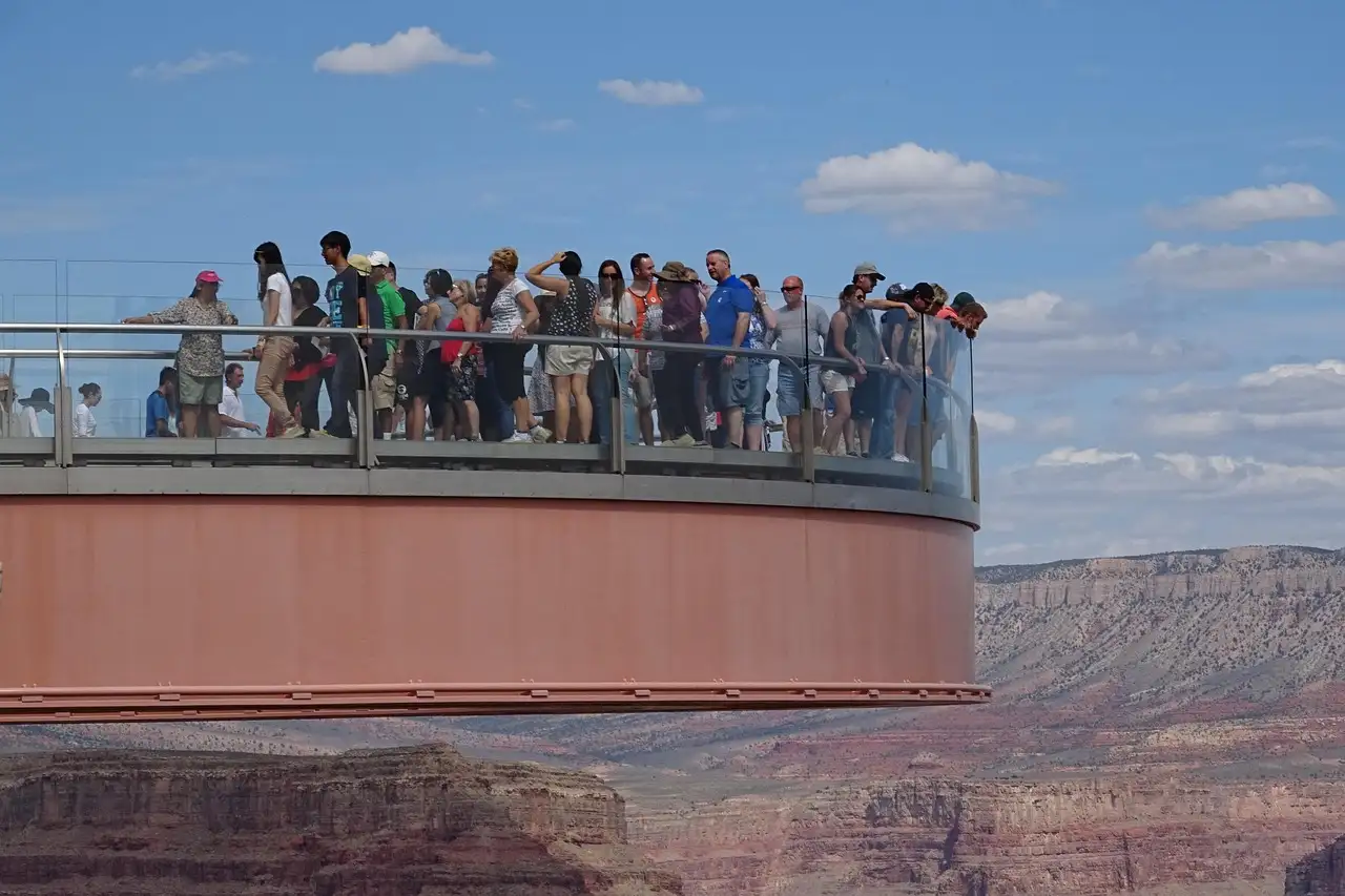The horseshoe Skywalk reaching out over the canyon, visitors along its glass rail