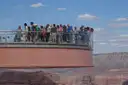 The horseshoe Skywalk reaching out over the canyon, visitors along its glass rail