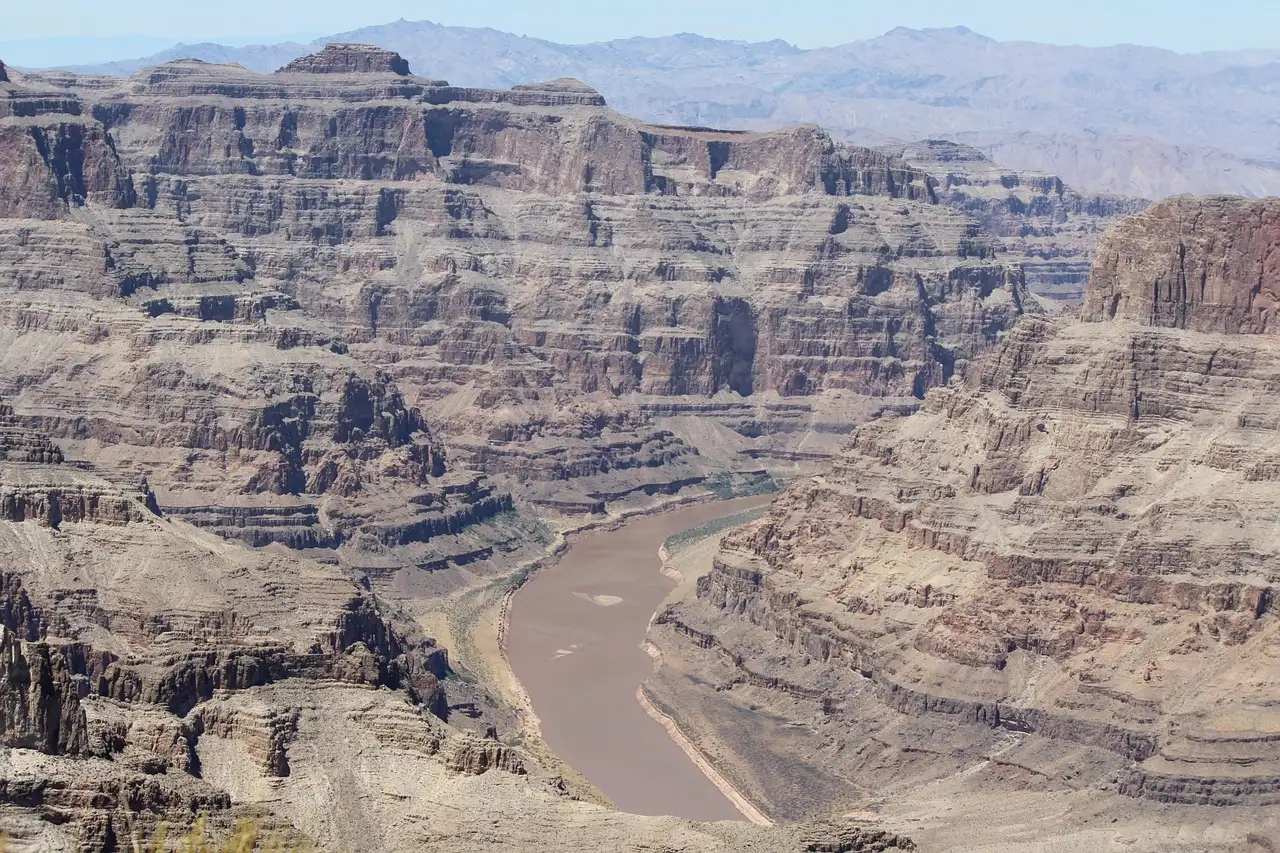 The Colorado River winding between layered cliffs in the Grand Canyon
