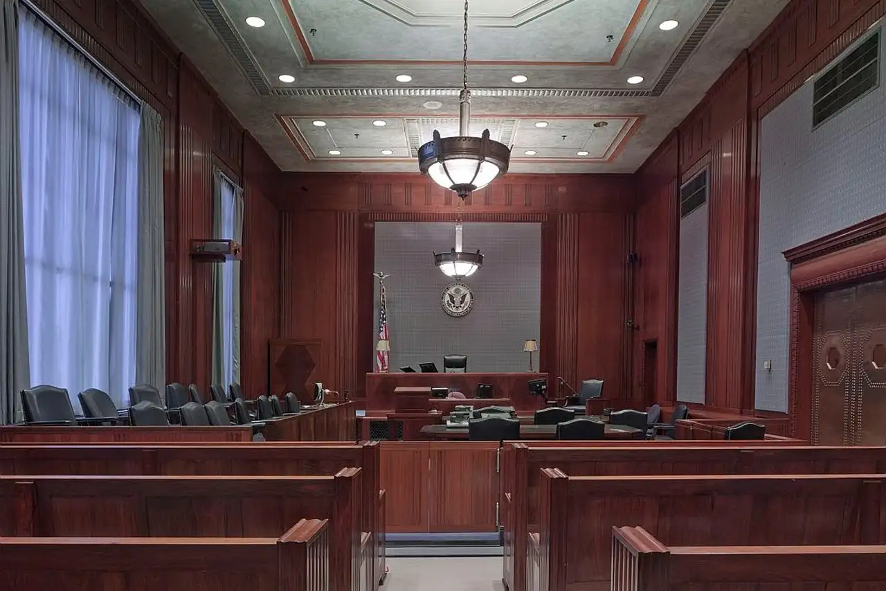Empty wood-panelled courtroom with public benches, jury box and judge's bench