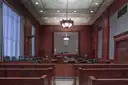 Empty wood-panelled courtroom with public benches, jury box and judge's bench