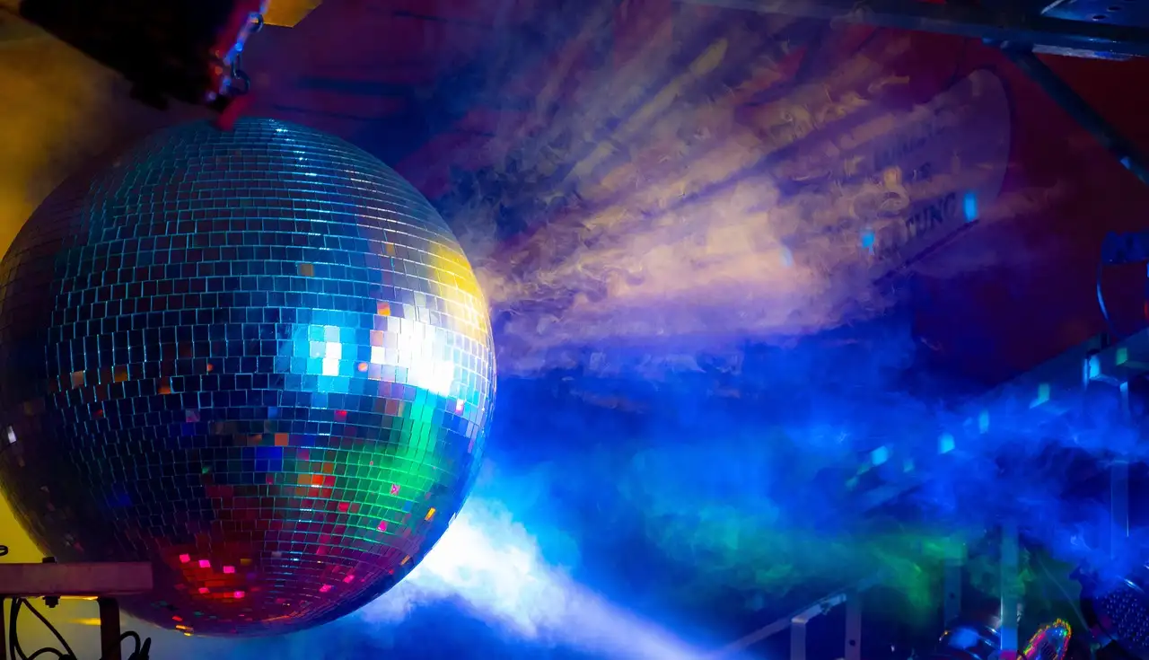 Mirror ball lit in blue, green and red in a hazy dark club