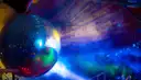 Mirror ball lit in blue, green and red in a hazy dark club