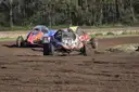 Three off-road racing buggies on a dirt track