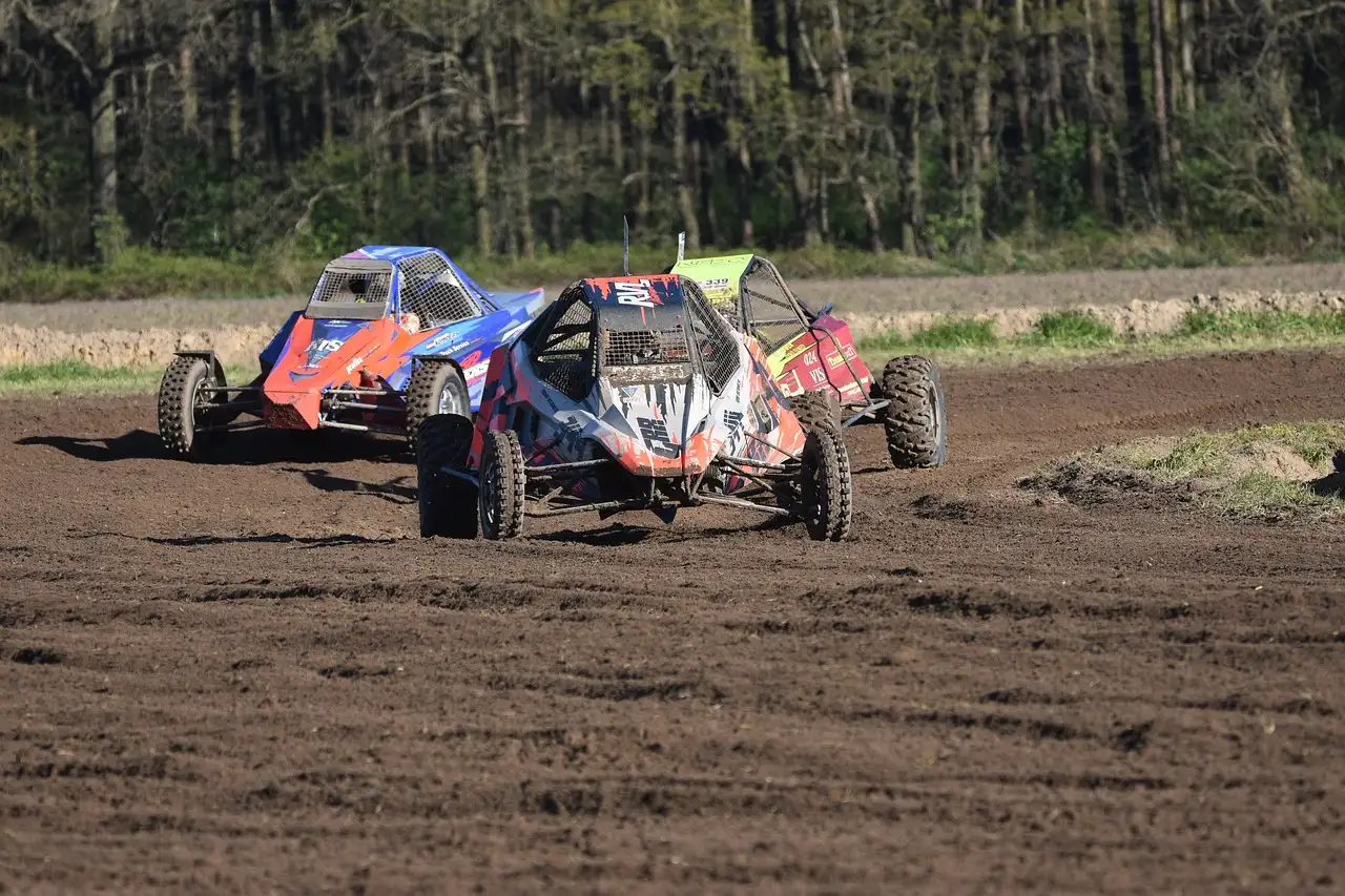 Three off-road racing buggies on a dirt track