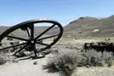 Rusted iron mine wheel lying in sagebrush on a dry hillside