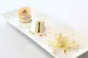 Long white plate with three small plated tastings