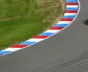 Empty race track bend with a red, white and blue curb