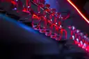 Glasses hanging from a bar rack in red and blue light