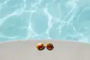 Sunglasses lying on the edge of a pool