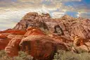 Orange-red sandstone boulders and cliffs in Red Rock Canyon, with desert shrubs below