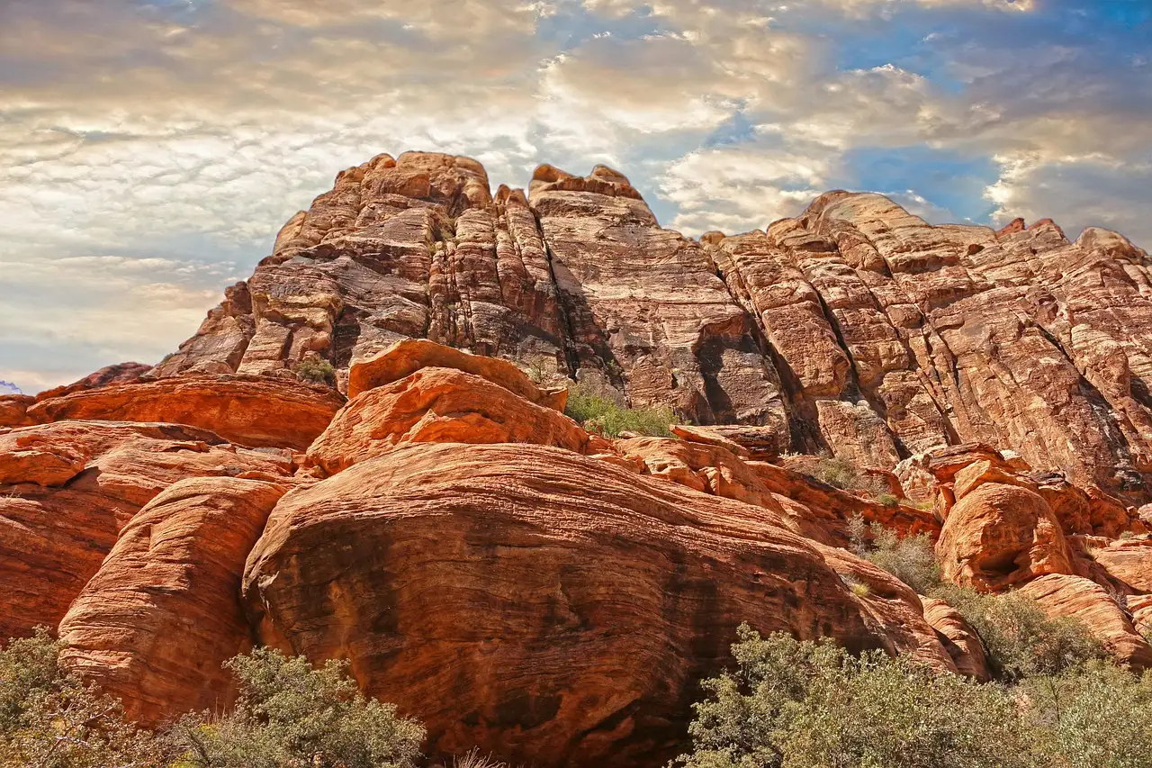 Orange-red sandstone boulders and cliffs in Red Rock Canyon, with desert shrubs below