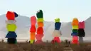 Close view of the painted boulder towers of Seven Magic Mountains against hazy desert mountains
