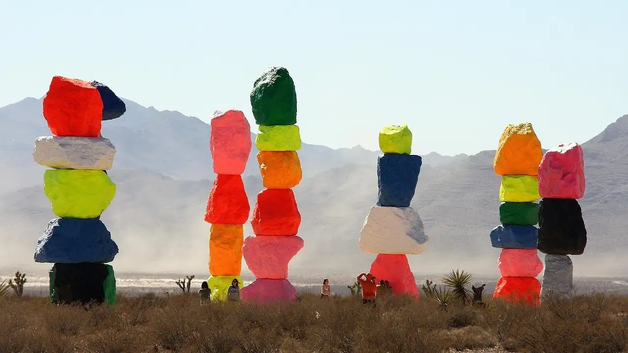 Close view of the painted boulder towers of Seven Magic Mountains against hazy desert mountains