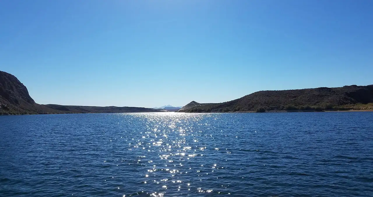 The Colorado River at Willow Beach glittering in the sun between low canyon hills